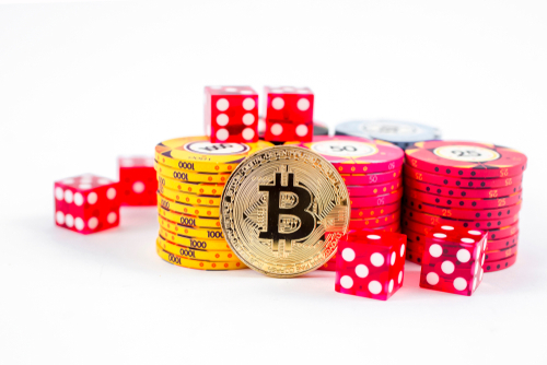 pile de jetons de casino se situant derrière une pièce de bitcoin dorée